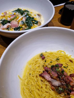 Japon carbonara makarnası kremalı et suyuyla servis edilir.