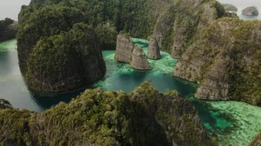 İHA, Raja Ampat 'ta bir uçurum ve lagünlerin, turkuaz suyun etrafında çekim yaptı.
