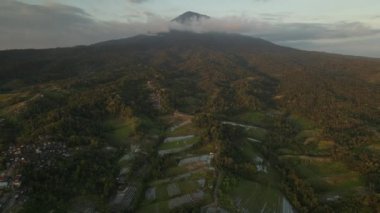 Bali 'deki Agung Dağı' nın gün batımı manzarası yeşil pirinç tarlalarıyla çevrili.