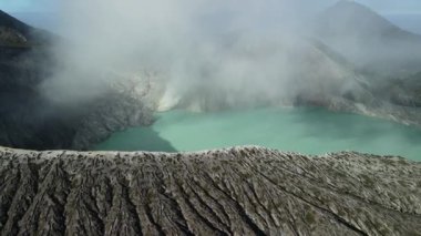 Kawah Ijen, doğu Java, Endonezya 'daki volkanik krater gölü, buharlı ve kayalık arazi manzarası.