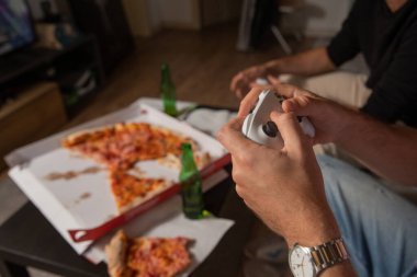 Arkadaşların pizza yerken ve bira içerken konsol oyunlarının keyfini çıkardıkları bir akşam..