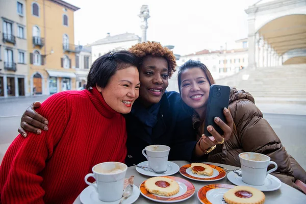 三个女性朋友在吃早餐的时候在手机上看东西 — 图库照片