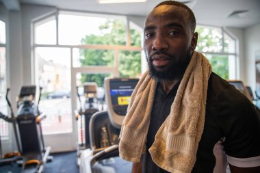 Spor salonunda koşan bir adam koşu bandında, sağlık ve zindelik konseptinde koşar.