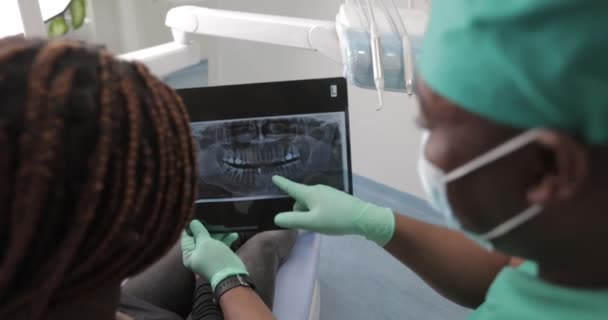 一名非洲牙医向牙科诊所的病人展示了X光照片 — 图库视频影像