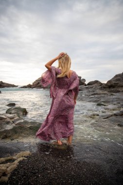 Sahildeki kız okyanusu, rahatlamayı ve meditasyonu gözlemliyor.