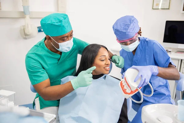 stock image A dentist gives a consultation to a patient and with his assistant they explain the teeth