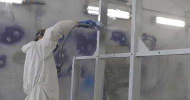 An industrial painter paints a metal structure, factory work.