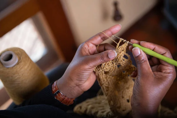 Hands of a woman doing crochet, home activities. Hand made fabric