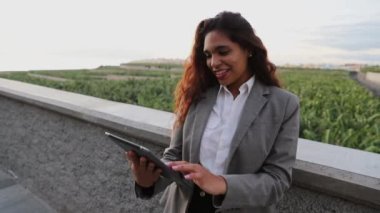 Latin businesswoman uses a tablet and has a surprised face