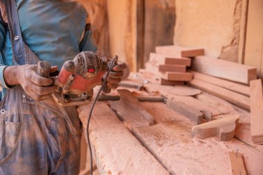 Close-up of a sander being held by an african carpenter at work