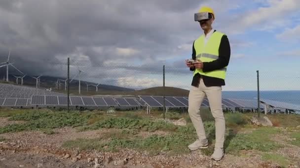 エンジニアは 太陽光発電所に仮想現実ヘッドセットを装着したFpvドローンをパイロットします — ストック動画