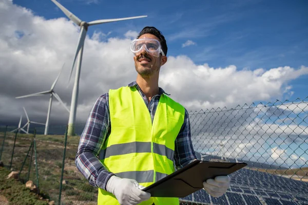 An engineer in a solar power plant at work, confident and smiling successful person.