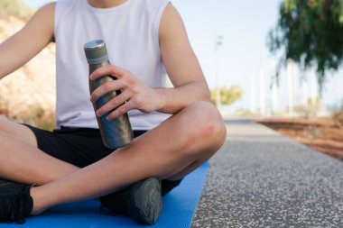 Spor yaparken elinde bir şişe su tutan bir sporcu, sporda su kaybı, sağda fotokopi alanı..