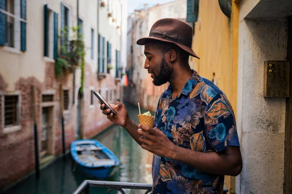 在威尼斯度假的时候 一位游客用他的智能手机 带着冰淇淋 很时髦 — 图库照片