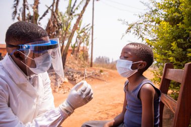 Afrika 'daki bir çocuk üzerinde moleküler test yapmak için örnek tutan bir doktor..