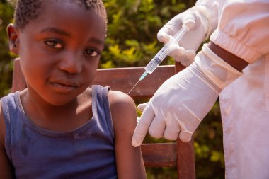 Afrikalı bir çocuk, Afrika 'da hastalıkların önlenmesi için bir doktor tarafından aşılandı..