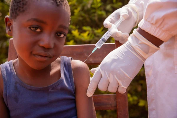 An African child is vaccinated by a doctor, disease prevention in Africa.