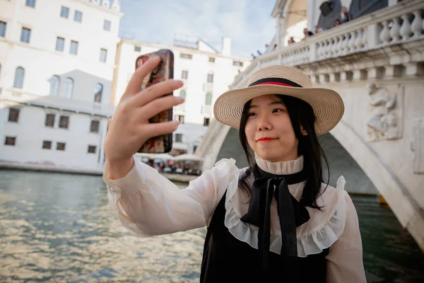 一名中国游客在威尼斯里阿尔托桥前自拍 — 图库照片