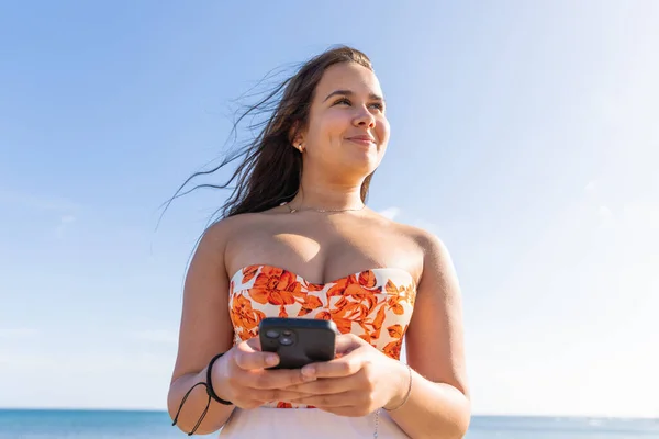 Dospívající Dívka Používá Svůj Smartphone Šťastný Zatímco Stojí Moře Jasnou — Stock fotografie