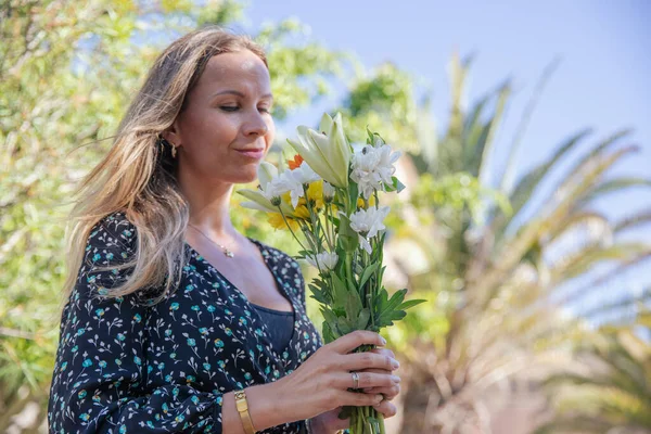Çekici Bir Kadın Açık Havada Çiçek Kokusu Alıyor — Stok fotoğraf