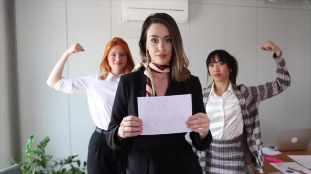 Seorang Pengusaha Memegang Kertas Girl Power Sementara Rekan Rekannya Menunjukkan — Stok Video