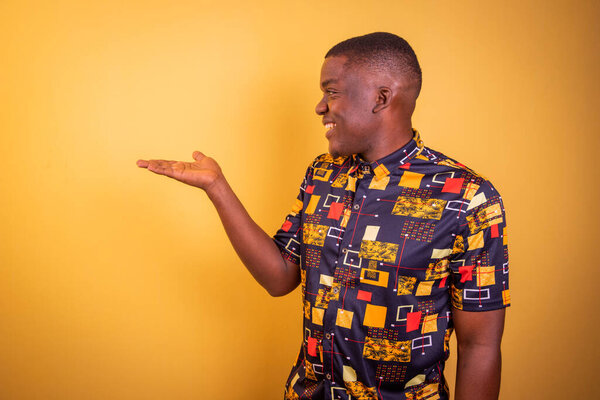 Happy African man raising hand, studio photo with copy space above hand for graphics