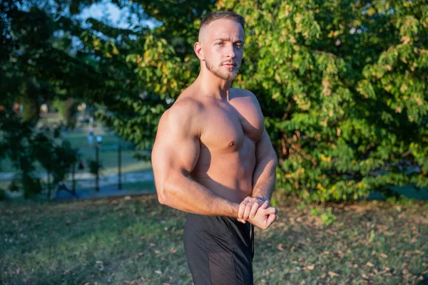 Kulturysta Pokazuje Swoje Bicepsy Podczas Treningu Parku Publicznym — Zdjęcie stockowe