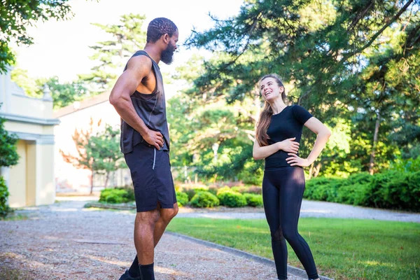 两个跑步者在户外运动时交谈 多种族的友谊 — 图库照片