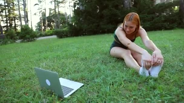 Una Chica Estira Mientras Toma Clases Línea Computadora Portátil Parque — Vídeos de Stock