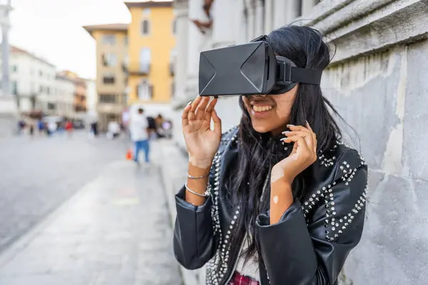 A girl uses virtual reality headsets and has fun while outdoors in the city