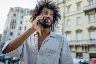 Çekici Doğu Afrikalı genç bir adamın portresi. Telefon görüşmesi yapıyor, fotokopi uzayı ile fotoğraf çekiyor.