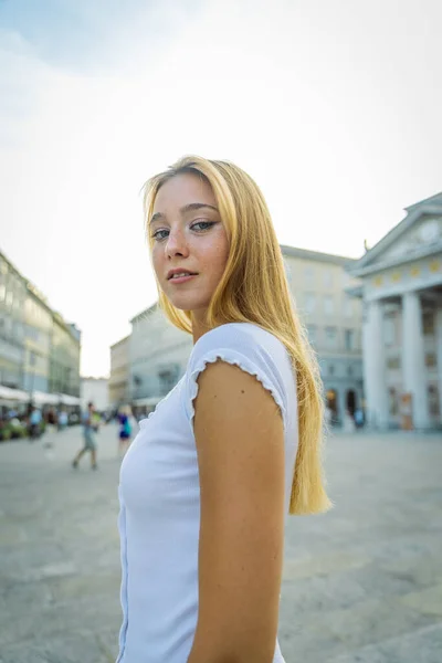 Portrait of an attractive young woman with confident expression in city center, vertical photo