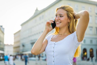 Bir kadın telefon eder ve konuşma sırasında mutlu olur.