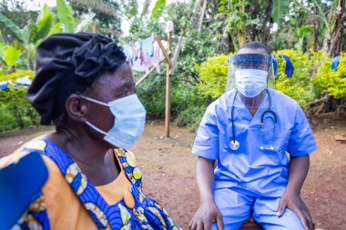 Afrikalı bir doktor köydeki yaşlı bir hastayı ziyaret ediyor..