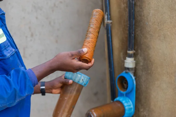 stock image Black blue collar worker shows dirty rusty filters that need to be changed.