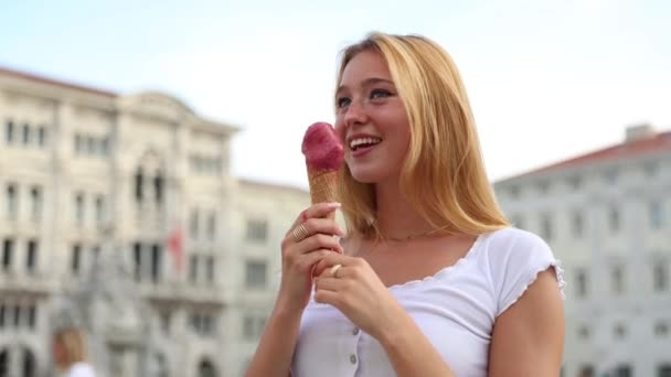 一个女孩在市中心吃冰淇淋 她很开心 — 图库视频影像
