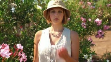 Bir kadın halka açık bir bahçede dururken öpücükler yolluyor, yazın tatlı bir kız.