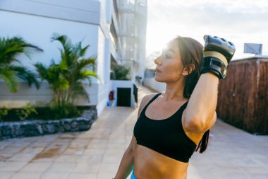 Siyah spor sutyen takan bir kadın kolunu uzatıyor. Kararlılık kavramı ve odaklanma kadın antrenmanına hazırlanırken