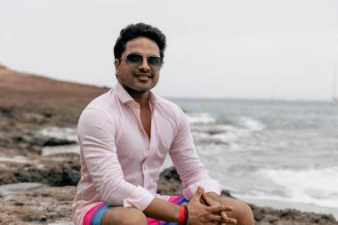 Sahilde kendine güvenen gülümseyen bir Hintlinin portresi