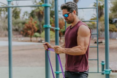 Kaslı, güçlü bir adam açık hava spor salonunda antrenman yapıyor. Aktif yaşam tarzı konsepti..