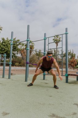 Bir atlet elastik bantla egzersiz yapıyor..