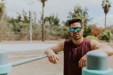 Açık hava spor salonunda antrenman yapan sağlıklı bir adamın portresi, fotokopi alanı olan bir fotoğraf..