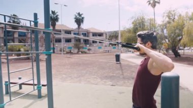 Açık hava jimnastik salonunda Ortaçağ Erkek Kolları ve Direniş Bandı Uygula