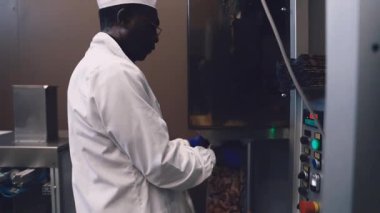 Ambarda badem ambalaj makineleri çalıştıran kıdemli Afrikalı işçi.