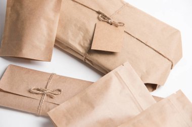 Karton kutular, ambalajlar, zarflar bir iple geri sarıldı, paketler beyaz arkaplanda boş etiketlerle oluşturuldu.