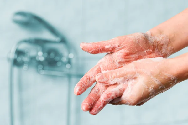 Woman washes her hands with foam soap