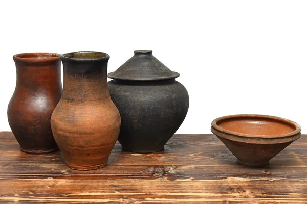 stock image Ukrainian traditional vintage clay kitchenware on wooden table. Rural clay pots, jug and bowl.