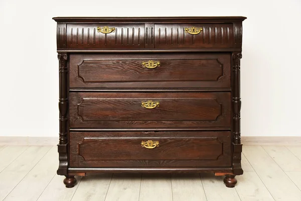 Old chest of drawers cupboard inside a room with light walls. Home interior vintage retro furniture bedchamber