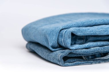 beyaz zemin üzerine mavi jeans yığını