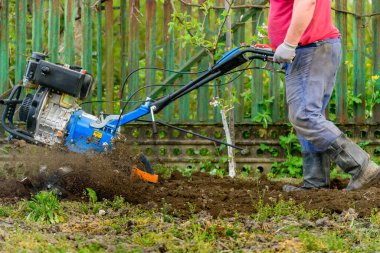 Erkek çiftçi tarlada çalışıyor. Saban bahçesi toprağı. Çiftçi bahçıvan toprak toprak rototiller ekin